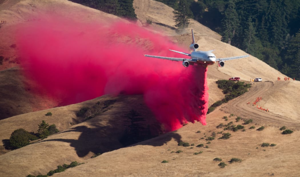 A plane drops fire retardant while battling the Soberanes Fire in Carmel Highlands, California on 23 July 2016.
