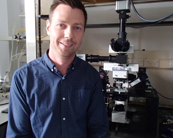 Man in front of a large microscope