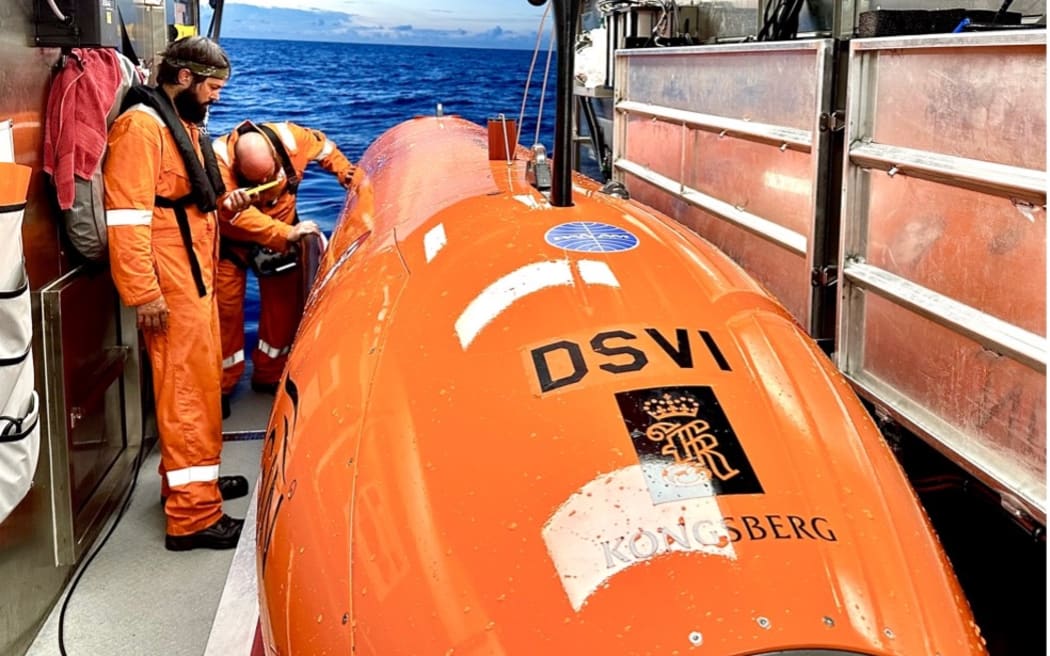 A man in an orange suit prepares to launch a Deep Sea Vision submersible.