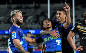 Blues halfback Taufa Funaki celebrates his try with Corey Evans and Rieko Ioane.