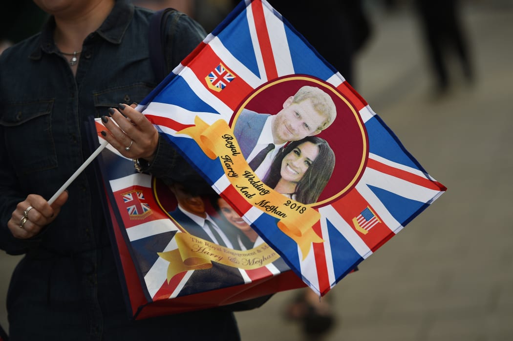 A visitor carries a bag featuring Britain's Prince Harry and US actress Meghan Markle as the country prepares for the Royal Wedding.