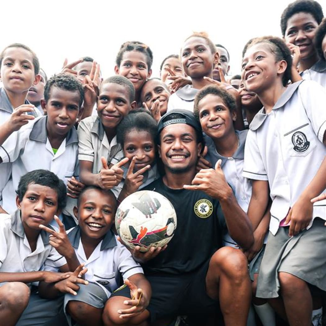 Wardstrip Demonstration Primary School students with a Solomon Kings FC player during the team's school visit in Port Moresby on Thursday. Photo: OFC