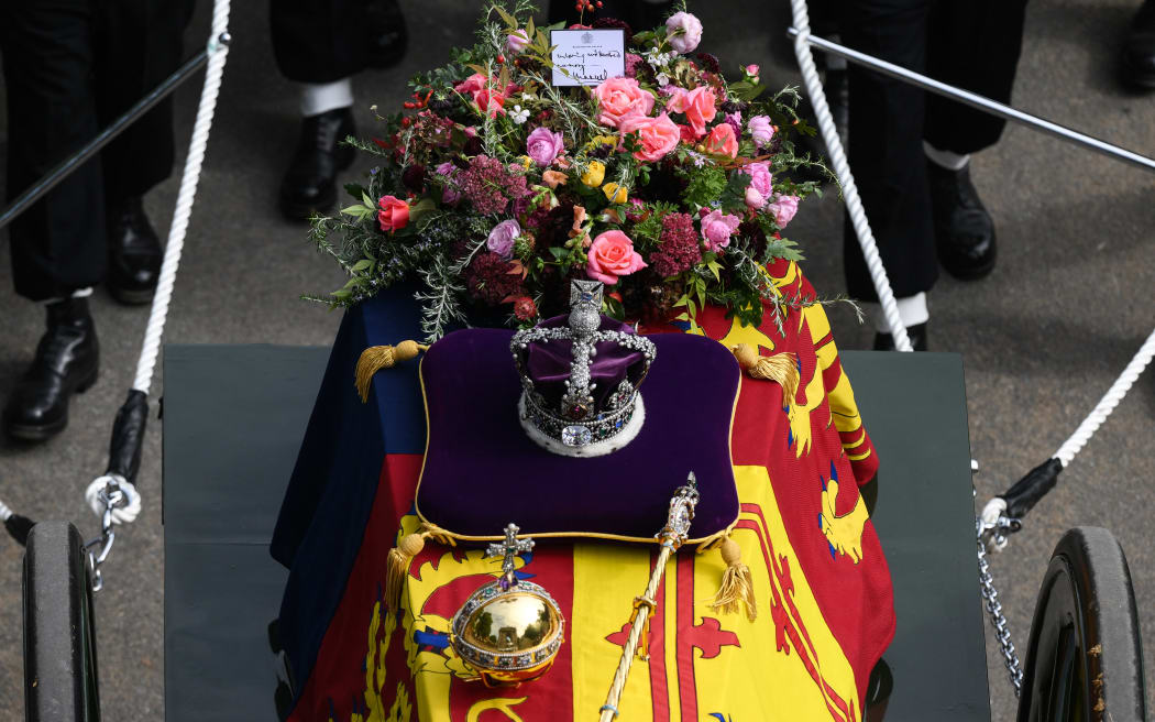 A note from Britain's King Charles III is seen with flowers on the coffin of Queen Elizabeth II, draped in the Royal Standard, on the State Gun Carriage of the Royal Navy at Wellington Arch in London on September 19, 2022, after the State Funeral Service of Britain's Queen Elizabeth II.