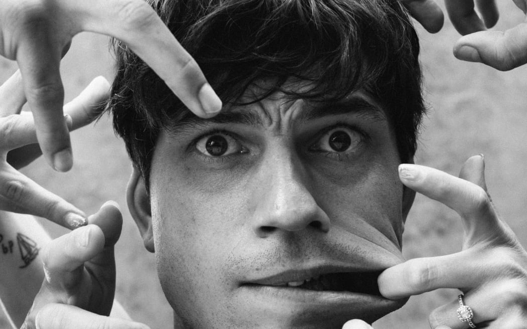 Choreographer Corey Baker with hands around his face mimicking 'Thing' from the TV show Wednesday.