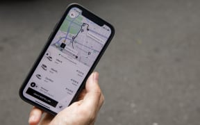 PRODUCTION - 01 September 2021, Berlin: The mobile app for ordering an Uber car is seen on a smartphone. Photo: Carsten Koall/dpa (Photo by CARSTEN KOALL / DPA / dpa Picture-Alliance via AFP)