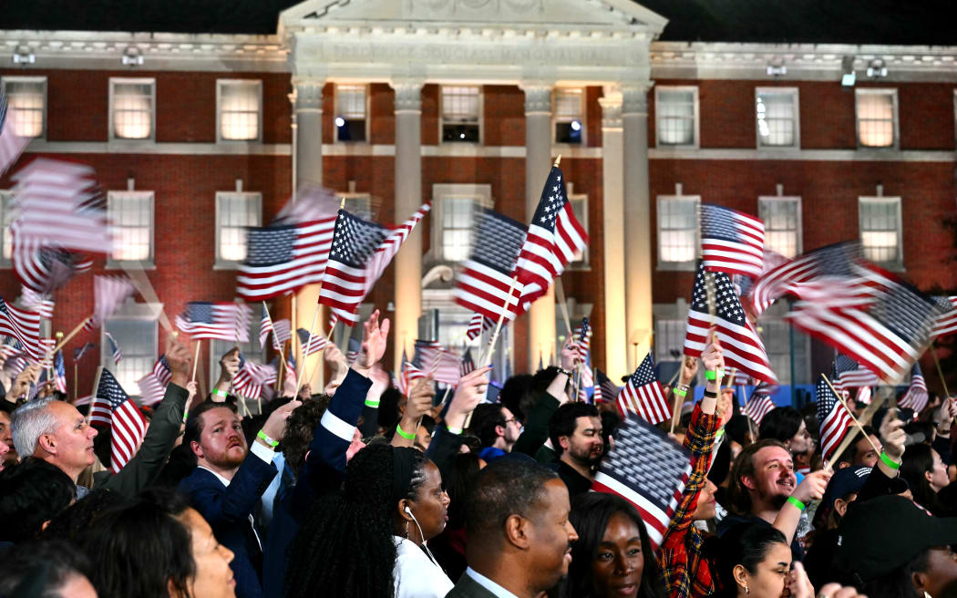 Supporters wave US flags as they watch election results during an election night event for US Vice President and Democratic presidential candidate Kamala Harris at Howard University in Washington, DC, on November 5, 2024. (Photo by ANGELA WEISS / AFP)