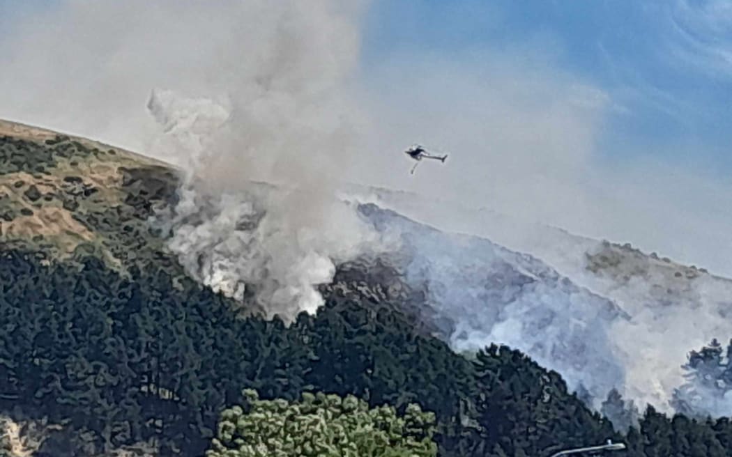 A helicopter fighting a fire in the Port Hills on 20 November 2023.