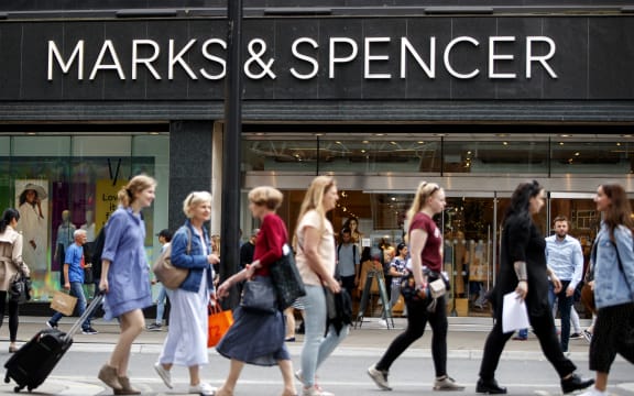 Shoppers walk past a Marks & Spencer shop on Oxford Street in central London on June 19, 2018. Major UK retailers are increasingly facing tough times in the face of intense online competition from the likes of US giant Amazon. Clothing-to-food retailer Marks & Spencer is meanwhile shutting more than 100 UK stores as it looks to shift at least one third of sales online. (Photo by Tolga Akmen / AFP)