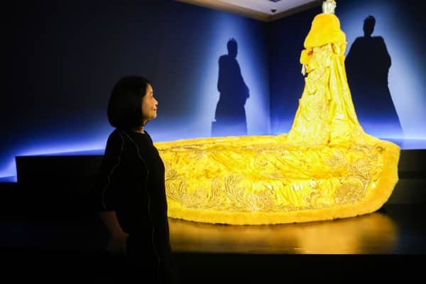 Chinese artist Guo Pei with The Yellow Queen - part of the exhibition Guo Pei: Fashion, Art, Fantasy, which was shown at the Auckland Art Gallery in 2023.