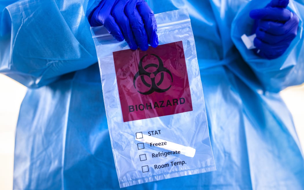 Covid-19 tester holds a bag after administering a test at Echo Park Stadium on December 30, 2020 in Parker, Colorado.