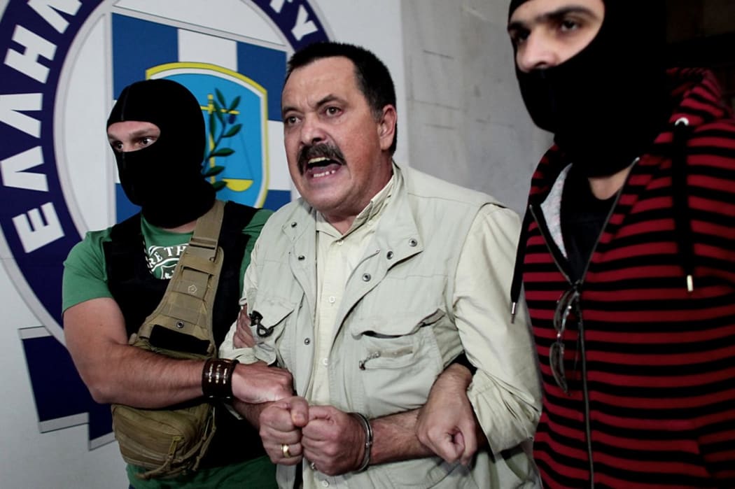 Christos Pappas of the extreme far-right Golden Dawn party, is escorted by police to the prosecutor's office on September 29, 2013