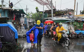 A rescue worker escorts a child to a waiting vehicle during an evacuation of informal settlers living along coastal areas in Manila