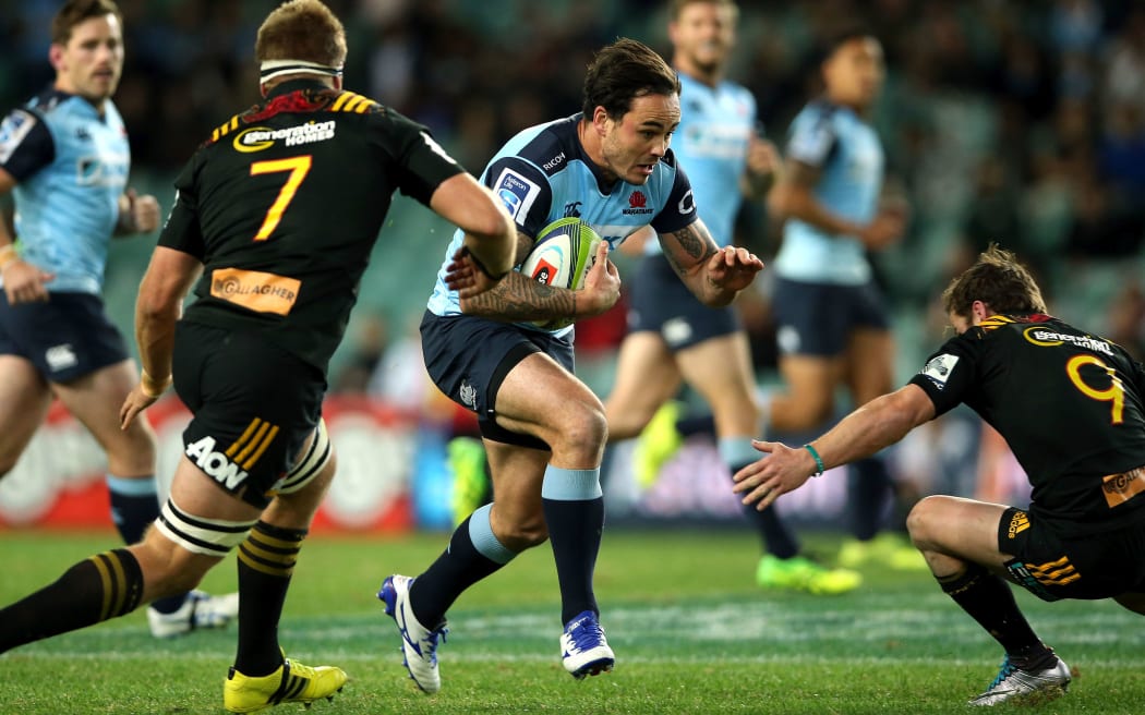 Zac Guildford tries to burst through the tackes of Chiefs players Brad Weber and Sam Cane.