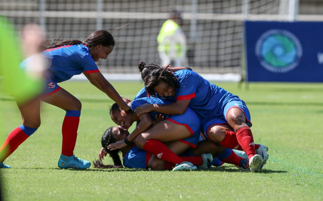 Teammates embrace Florencina Kalifa as she celebrates her goal against Koloale FC