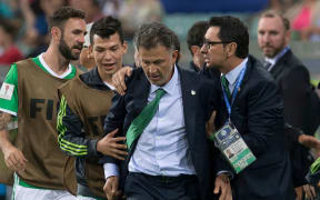 Juan Carlos Osorio (MEX) restrained by players and officials during the match Mexico vs New Zealand.