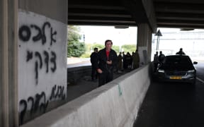 People take shelter under a bridge as sirens sounded near Tel Aviv on February 28, 2026, following the announcement that Israel had launched a “preemptive strike” on Iran. President Donald Trump urged Iranians on February 28 to take over their government as US forces began a large-scale attack on the country's military. (Photo by ilia YEFIMOVICH / AFP)