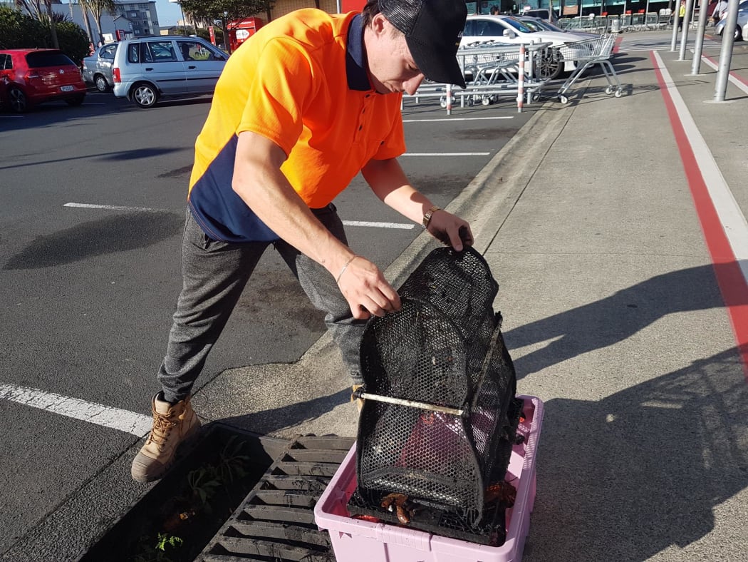 Cain Grogan empties the rubbish caught in the trap, which has been stopped from going down the drain and onto the sea.