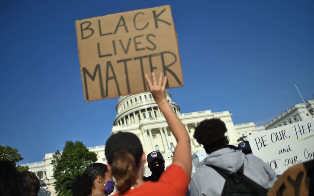 Protesters hold signs as they demonstrate in front of the United States Capitol in Washington, DC, on 2 June, 2020.