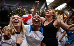 England fans celebrates the third goal from England as they watch a screen showing the Women's World Cup semi-final football match between Australia and England, at Boxpark Wembley in London on August 16, 2023. (Photo by JUSTIN TALLIS / AFP)