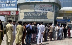 KABUL, AFGHANISTAN 15: Afghan people line up outside AZIZI Bank to take out cash as the Bank suffers amid money crises in Kabul, Afghanistan, on August 15, 2021.