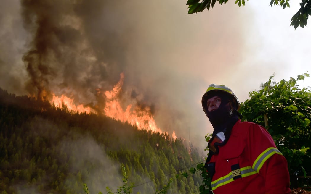 A firefighter looks on as he works to extinguish a wildfire in Carvalho, next to Pampilhosa da Serra.