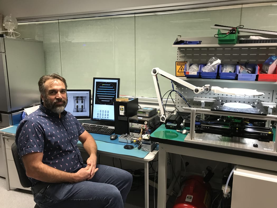 Bryon Wright sits next to test equipment the lab has made to check the sensor.