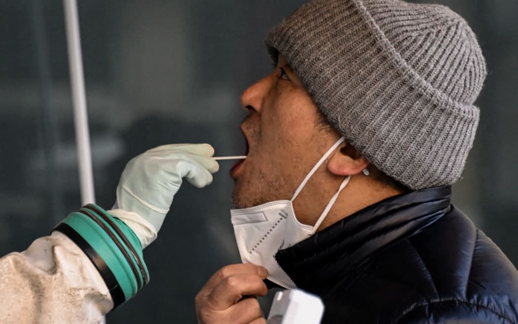 A health worker takes a swab sample from a man to be tested for the Covid-19 coronavirus at a hospital in Beijing on December 26, 2022.