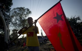A National League for Democracy supporter holds the party flag (file photograph).