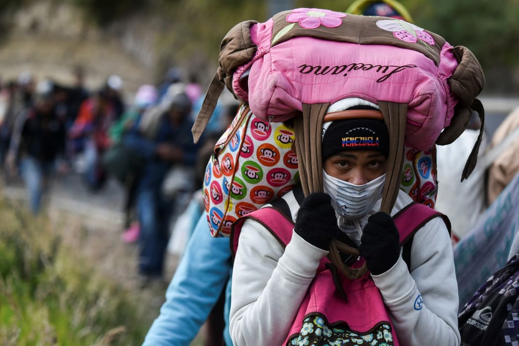 A Venezuelan migrant woman heading to Peru walks along the Pan American highway in Tulcan, Ecuador, after crossing from Colombia, 21 August 2018.