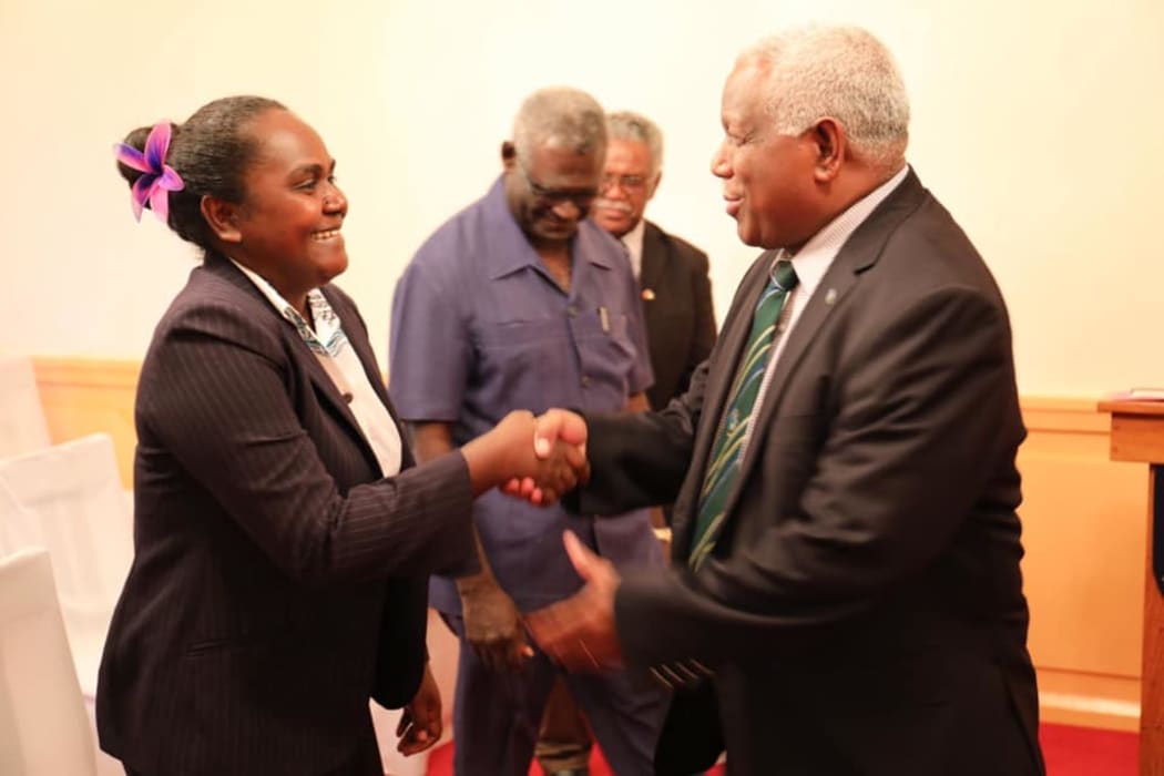 Solomon Islands' new Minister for Women, Youths, Children and Family Affairs,  Lanelle Tanangada, shakes hands with prime minister Rick Hou after her swearing in ceremony at Government House in Honiara.