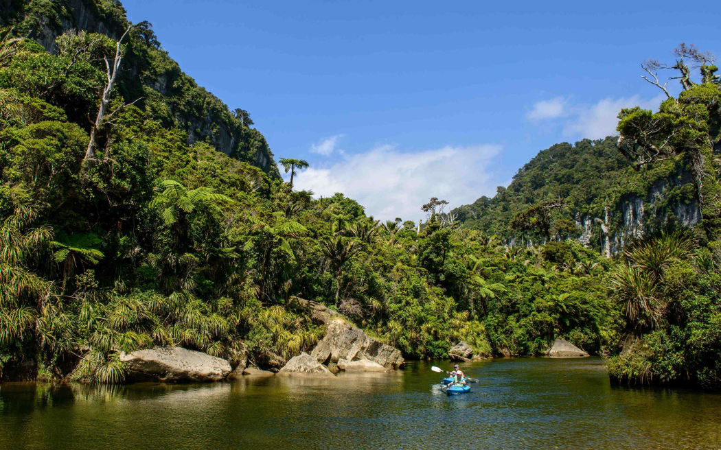 Two kayakers paddle on the Porarari River and enjoy the jungle in Paparoa National Park on February 10, 2016 in Punakaiki, New Zealand.
