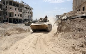 A picture taken on April 8, 2018, shows Syrian Army soldiers advancing in an area on the eastern outskirts of Douma.