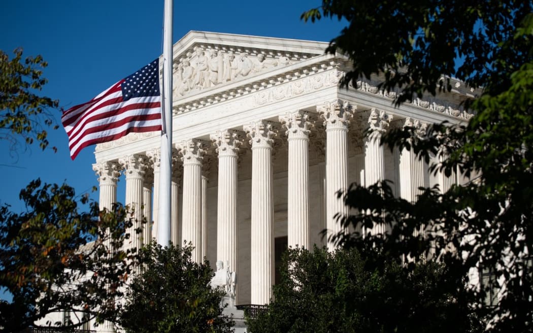 The American flag flies at half staff for late US Supreme Court Justice Ruth Bader Ginsberg outside the US Supreme Court in Washington, DC