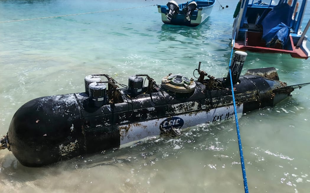 A picture taken on April 6, 2026, shows a torpedo-like 3.7-metre-long and 65-centimetre-wide object, discovered by a fisherman near the Lombok Strait after being towed ashore onto a beach on Gili Trawangan, West Nusa Tenggara. The Indonesian navy said on April 9, it was investigating a torpedo-like object discovered by a fisherman near the Lombok Strait, a key maritime route connecting the Indian and Pacific Oceans. (Photo by AFP)