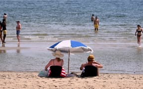 People cool off in heatwave conditions at Melbourne's St Kilda Beach on November 22, 2024. (Photo by William WEST / AFP)