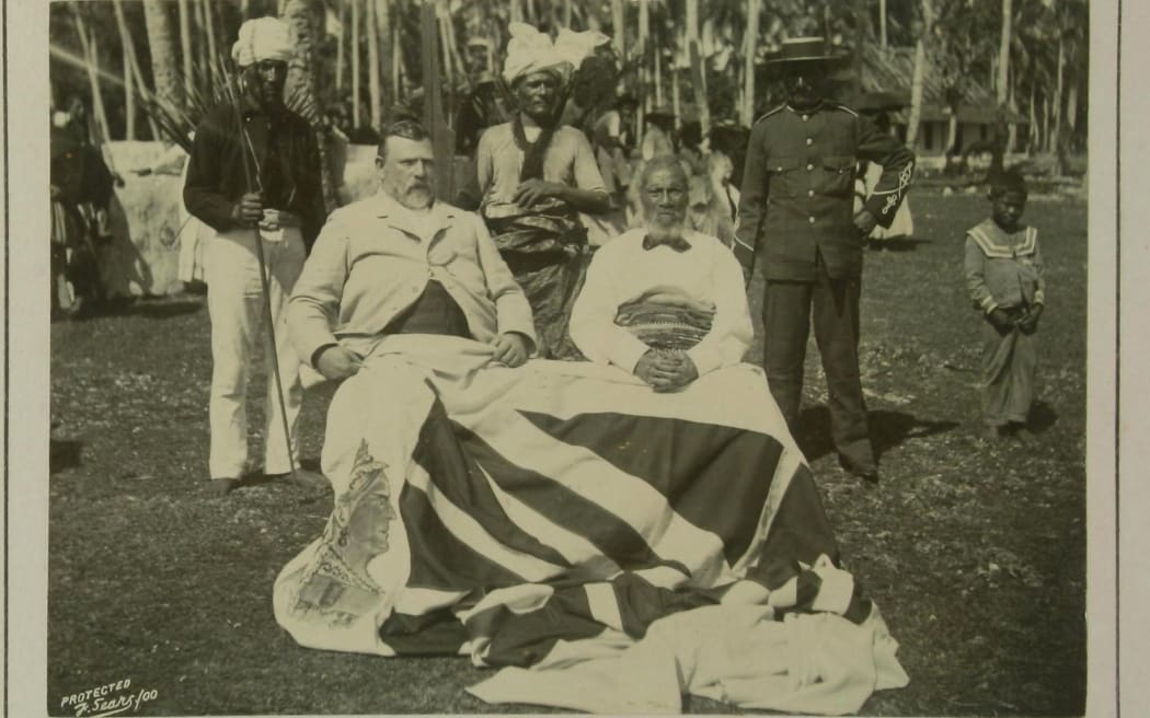 ‘The two kings, “Dick” and Togia’ under the grand old flag. NZ Premier Richard Seddon toured the Pacific in May 1900. He's pictured with King Togia-Pule-toaki.