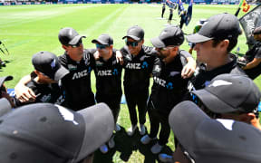 New Zealand captain Mitchell Santner talks to his team in a huddle.