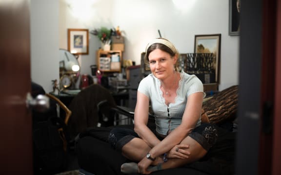 Kristine, pictured sitting on the bed in her room.