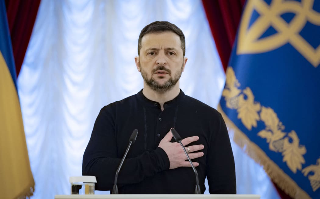This handout picture taken and released by Ukrainian Presidential Press Service on 26 December, 2024 shows Ukrainian President Volodymyr Zelensky (L) stands for the National anthem of Ukraine during an award ceremony in Kyiv, amid the Russian invasion in Ukraine. (Photo by Handout / UKRAINIAN PRESIDENTIAL PRESS SERVICE / AFP) / RESTRICTED TO EDITORIAL USE - MANDATORY CREDIT "AFP PHOTO / HANDOUT / UKRAINIAN PRESIDENTIAL PRESS SERVICE" - NO MARKETING NO ADVERTISING CAMPAIGNS - DISTRIBUTED AS A SERVICE TO CLIENTS