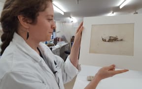 Conservationist Josefin Bergmark-Jimenez, with the painting she discovered.