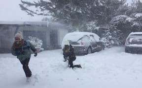 Guests play in the snow outside a lodge near the Tongariro Crossing.