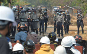 Riot police hold their firearms as they face off with protesters during a demonstration against the military coup in Naypyidaw.