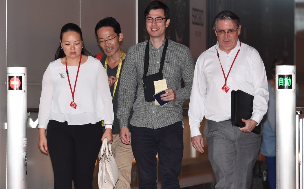 Australian student Alek Sigley (C) smiles as he arrives at Haneda International airport in Tokyo on July 4, 2019, following his release. -