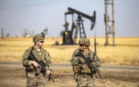 US troops patrol near an oil well in al-Qahtaniyah in Syria's northeastern Hasakah province, close to the border with Turkey, on June 14, 2023. Twenty-two US soldiers were injured in a helicopter accident in northeastern Syria at the weekend that did not involve any reported enemy fire, US Central Command said on June 13. (Photo by Delil souleiman / AFP)