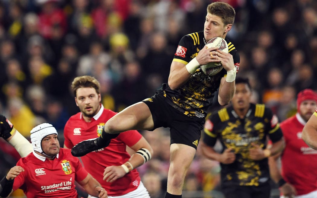Jordie Barrett of the Hurricanes leaps for a high ball against the Lions.