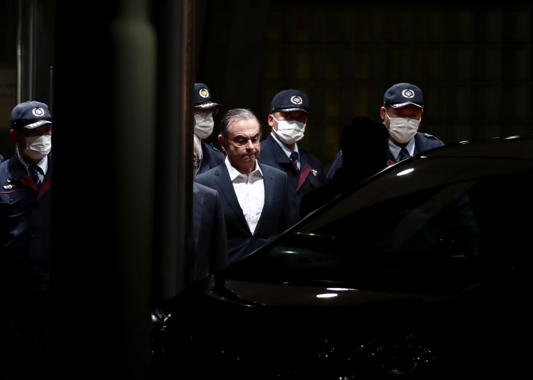 Carlos Ghosn is escorted from the Tokyo detention house after his release.