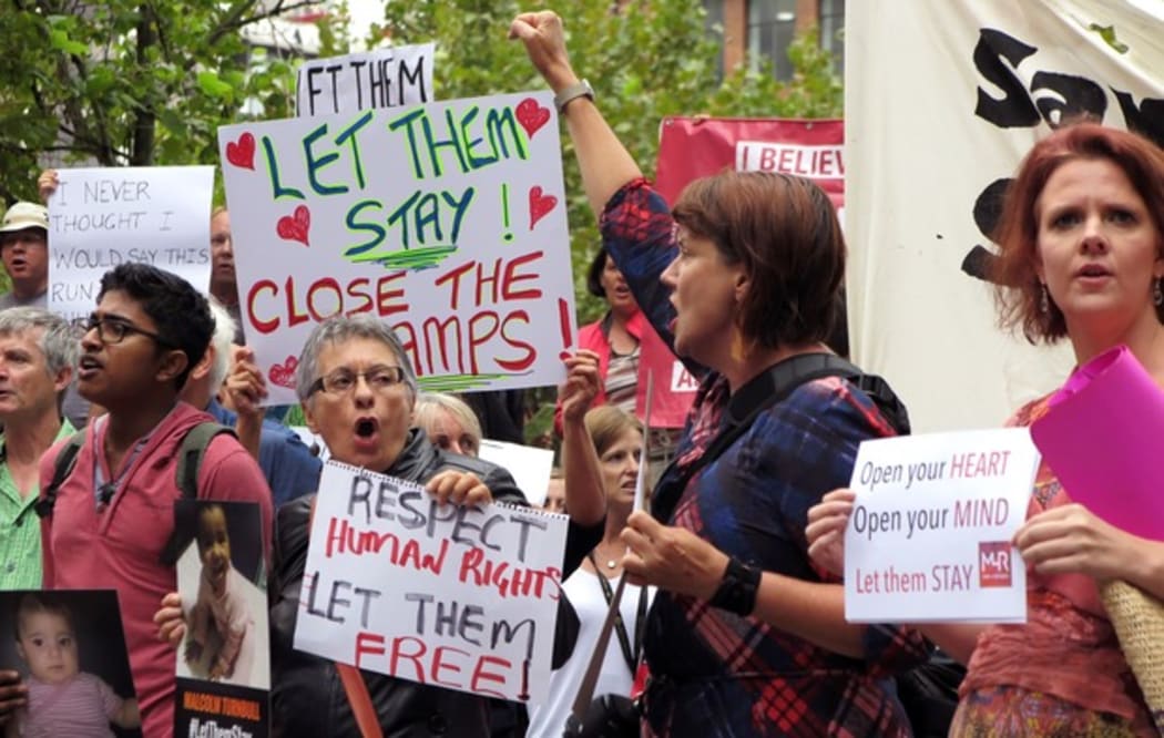 People hold up placards at a protest outside an immigration office in Sydney on 4 February 2016.