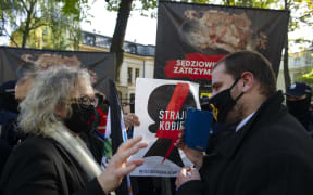 Woman's rights activist and co-founder of All-Poland's Women Strike, Marta Lempart (left) argues with a pro-life supporter as a protest and counter-protest took place prior to the Polish Constitutional Tribunal issuing its decision on abortion.