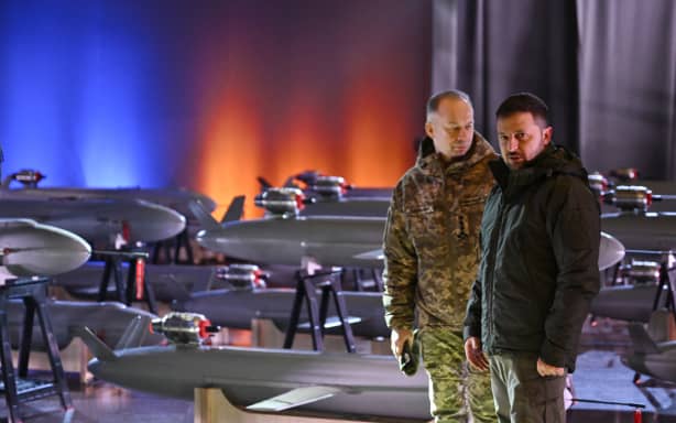Ukrainian President Volodymyr Zelensky (R) and Commander-in-Chief of the Armed Forces of Ukraine Oleksandr Syrsky (L) speak next to the first batch of Ukrainian made drone missiles “Peklo” (Hell) delivered to the Defence Forces of Ukraine in Kyiv on December 6, 2024, amid the Russian invasion of Ukraine. - December 6, 2024 marks the 33th anniversary of the Armed Forces of Ukraine. (Photo by Genya SAVILOV / AFP)