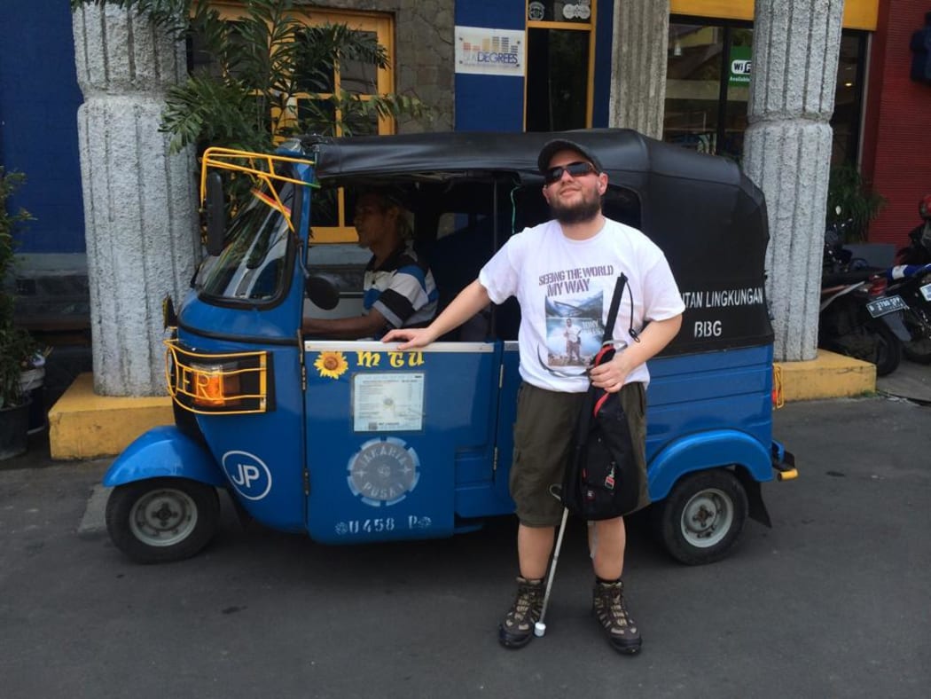 Tony Giles in Jakarta standing in front of a bajaj